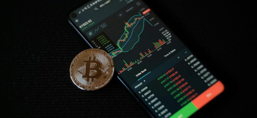 a bitcoin sitting on top of a smart phone