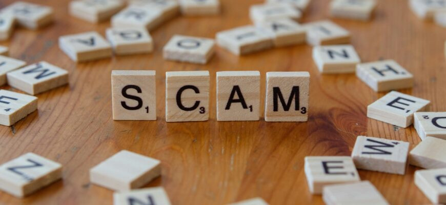 Scam spelled with scrabbles on a wooden table